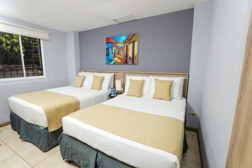 a bedroom with two beds in a room at Hotel Los Altos Express "La Centroamerica" in Managua