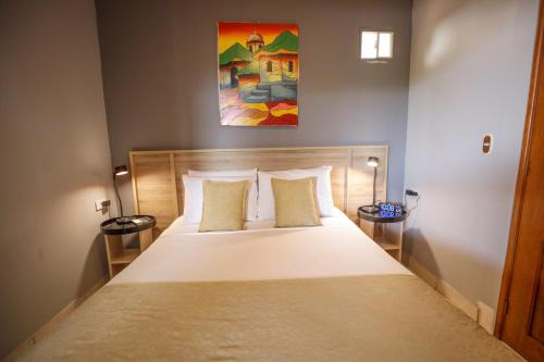 a bedroom with a large bed with two pillows at Hotel Los Altos Express "La Centroamerica" in Managua