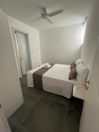 a bedroom with a bed with a ceiling fan at GOZO DIVE Residence in Xlendi
