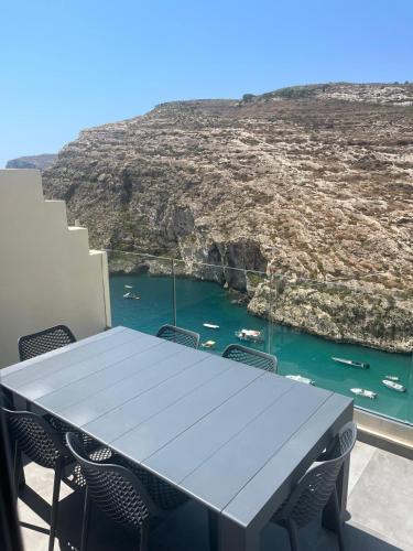 a table with chairs and a view of a bay at GOZO DIVE Residence in Xlendi