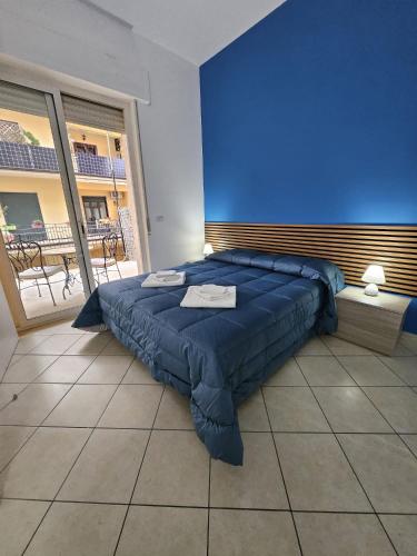 a bed in a room with a blue wall at B&B mirò e appartamenti in Marina di Gioiosa Ionica