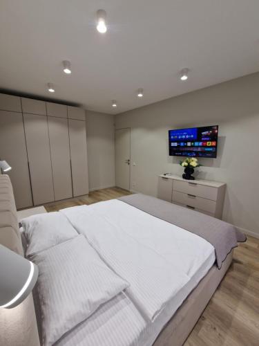 a bedroom with a large bed and a tv on the wall at Apartament on StyleUp StayRent Lutsk in Lutsk