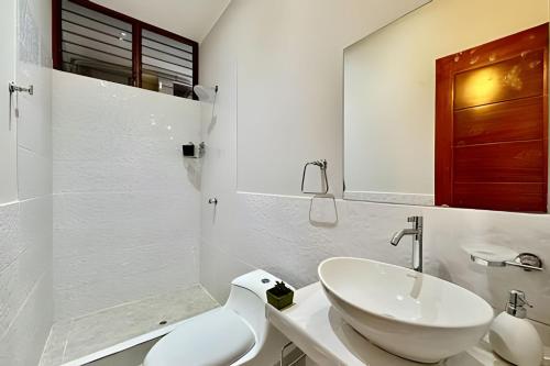 Un baño blanco con lavabo e inodoro. en Vive a 5min centro 2HAB con A/C Terraza y Parrilla, en Tarapoto