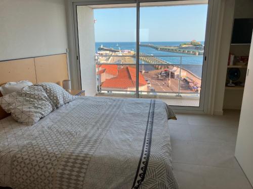 une chambre avec un lit et une grande fenêtre dans l'établissement le 5ème ASTRO - vue mer et chenal, à La Chaume