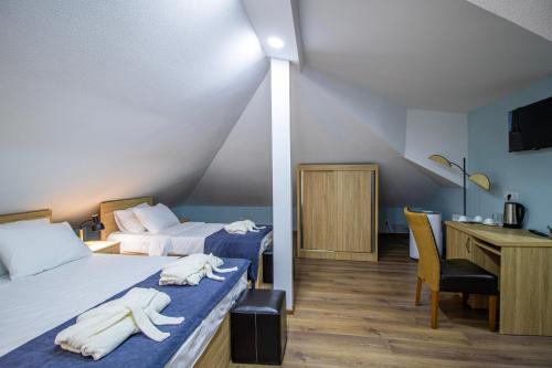 a hotel room with two beds and a desk and a desk at Green Garden Guesthouse in Tbilisi City