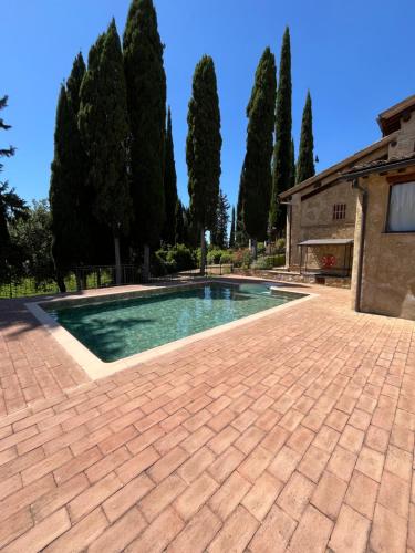 a swimming pool in a yard with trees at Podere Le Grotte in San Gimignano