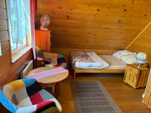 a room with two beds and a table and chairs at Nirwana - Domki Całoroczne w Solinie in Solina