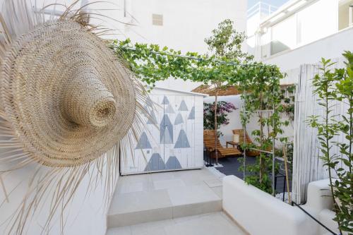 a courtyard with a rattan hanging basket and plants at AGLEA trulli e suite in Alberobello