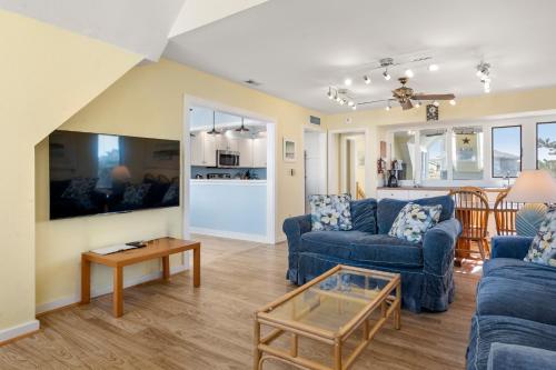 a living room with two blue couches and a table at Fun2Sea in Corolla