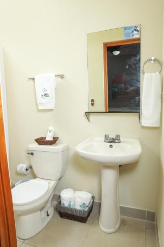 a bathroom with a toilet and a sink at Hotel Los Altos Express "La Centroamerica" in Managua