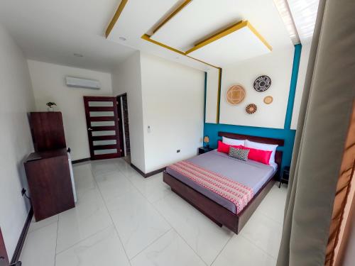 a bedroom with a bed with pink pillows at Villa del Mar Hotel Boutique in Cahuita