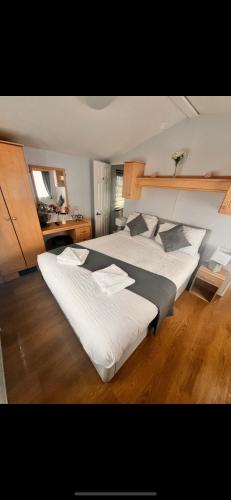 two large beds in a room with wooden floors at Vacation Escape - Valley Farm -Clacton-on-sea - Holiday Park in Clacton-on-Sea
