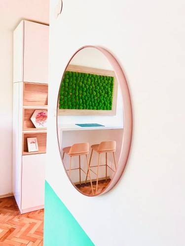 a mirror in a room with a table and two stools at Happy Sweet Apartment in Niš