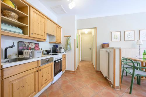 a kitchen with wooden cabinets and a table at Landhaus Hindenburg in Bad Gleichenberg