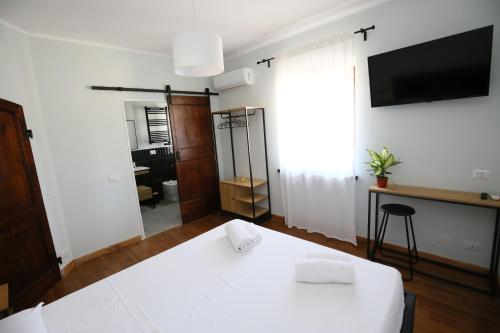 a room with a white table and a tv at Areté rooms in Cupra Marittima