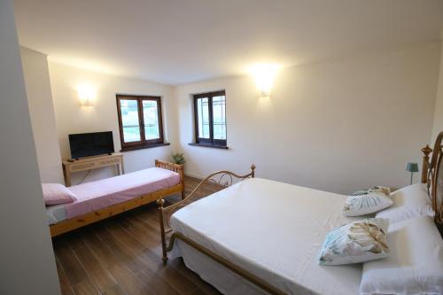 a bedroom with two beds and a flat screen tv at Areté rooms in Cupra Marittima