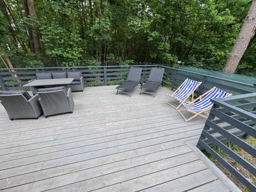 a wooden deck with chairs and a table and chairs at Forest Haven in Mielno