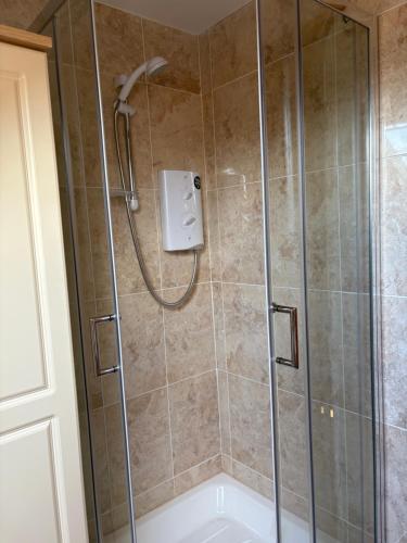 a shower in a bathroom with a glass door at Tigh Oisin in Lettermullan