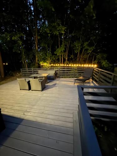 a deck with chairs and lights at night at Forest Haven in Mielno
