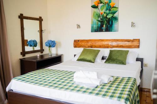a bedroom with two beds and a mirror and a vase of flowers at Livada in Gonio