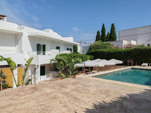 a villa with a swimming pool next to a building at Hostal Oasis Dor in Cala d´Or
