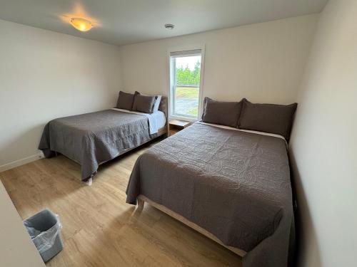 a bedroom with two beds and a window at Cavendish Lodge & Cottages in Cavendish