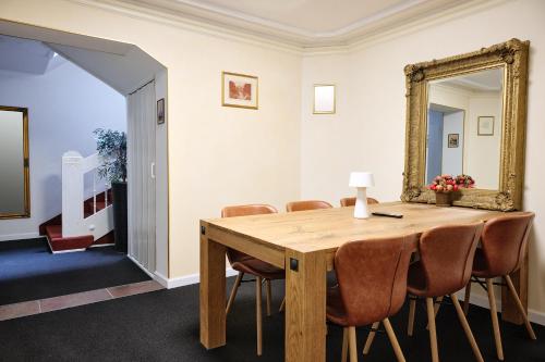 a dining room with a table and a mirror at Esos Hotel Quelle in Bad Ragaz