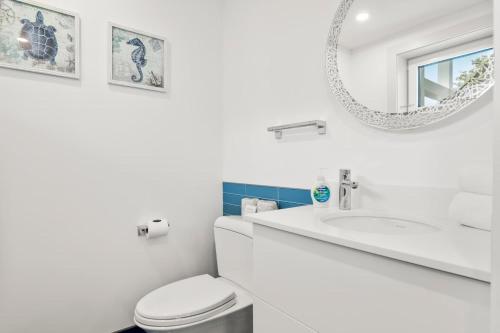 a white bathroom with a toilet and a mirror at Coastal Luxury Near Wellfleets Best Beaches in Wellfleet