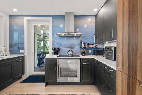 a kitchen with black cabinets and a stainless steel oven at Coastal Luxury Near Wellfleets Best Beaches in Wellfleet