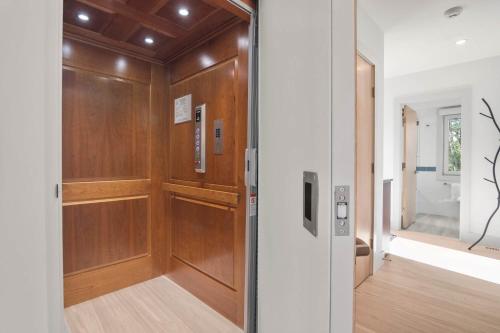 a hallway with wood paneling and a sliding door at Coastal Luxury Near Wellfleets Best Beaches in Wellfleet