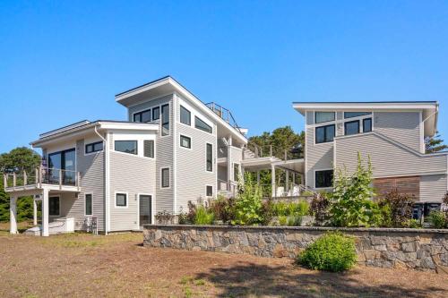 a large house with a stone wall in front of it at Coastal Luxury Near Wellfleets Best Beaches in Wellfleet