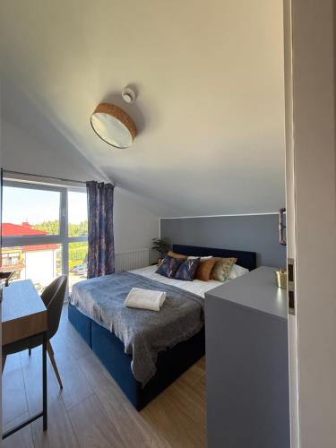 una camera da letto con un letto, un tavolo e una scrivania di Apartamenty Ku Słońcu - Kuracyjna - Jastrzębia Gora a Jastrzębia Góra