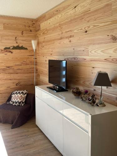 un salon avec une télévision sur une commode blanche dans l'établissement Appartement Studio cabine Saint Lary, à Saint-Lary-Soulan