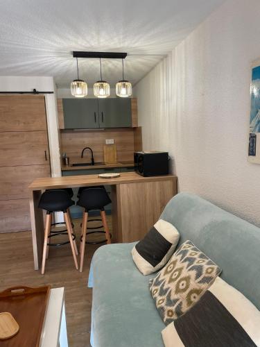 une chambre avec un canapé et une cuisine avec une table dans l'établissement Appartement Studio cabine Saint Lary, à Saint-Lary-Soulan