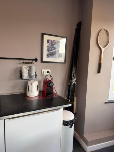 a kitchen with a counter with a tennis racket on the wall at Bel appart - Tilff in Tilff