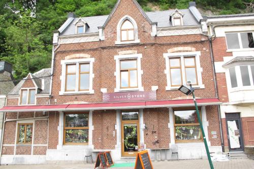 un bâtiment en briques avec un magasin dans une rue dans l'établissement Stone Station, à Esneux