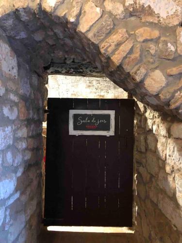 a black garage door in a stone wall at Can Ollé in Rubio