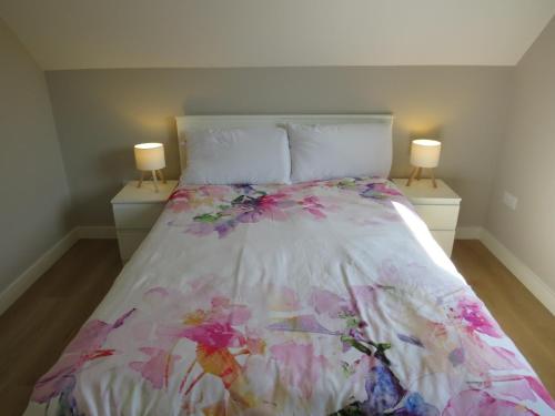 a bedroom with a bed with a floral bedspread at Dooneen House in Clifden