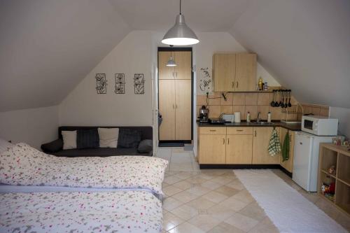 a bedroom with a bed and a small kitchen at Szent Anna Vendégház in Bükkszék