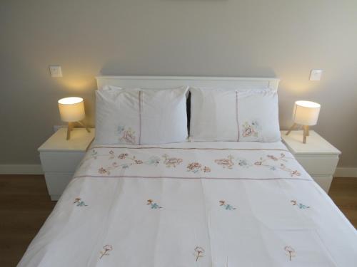 a bedroom with a white bed with two lamps at Dooneen House in Clifden