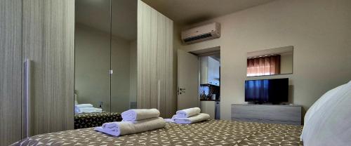 Un dormitorio con una cama y dos sillas y un televisor. en Must Apartaments, en Polignano a Mare