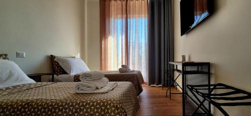 Una habitación de hotel con dos camas y una ventana. en Must Apartaments, en Polignano a Mare