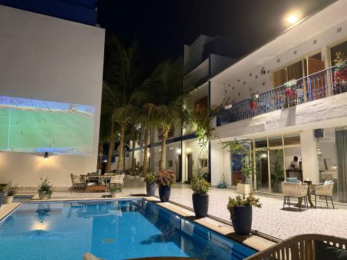 a swimming pool in a building with a soccer game on a screen at فلل الخالدية in Jeddah