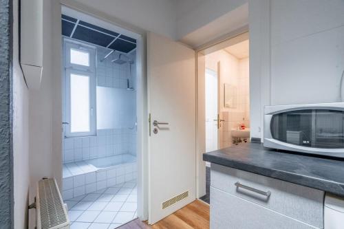 Il comprend une cuisine équipée d'un four micro-ondes et une salle de bains pourvue d'une baignoire. dans l'établissement traumhaftes zentrales Apartment zum Entspannen, à Leipzig