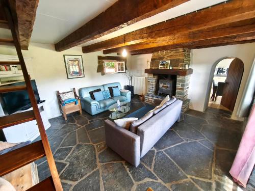 a living room with a couch and a fireplace at Gîte Lann Avel Classé 3 étoiles WIFI CALME CAMPAGNE in Laniscat