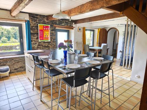 a dining room with a table with chairs and a counter at Gîte Lann Avel Classé 3 étoiles WIFI CALME CAMPAGNE in Laniscat