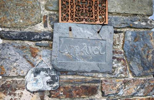 a sign on the side of a stone wall at Gîte Lann Avel Classé 3 étoiles WIFI CALME CAMPAGNE in Laniscat