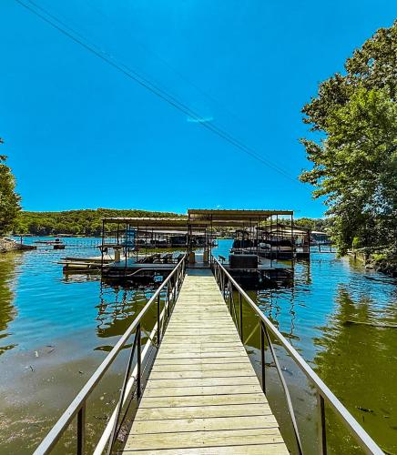 a wooden dock with boats on the water at Historic Lakefront Log Cabin4bd3badockfirepit in Camdenton