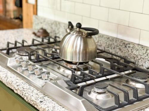 a tea kettle sitting on top of a stove at Historic Lakefront Log Cabin4bd3badockfirepit in Camdenton