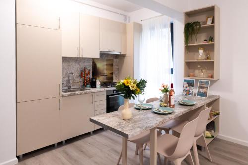 a kitchen with a table with flowers on it at Soni Exclusive Apartments 1218 Plaza with Private Parking & Self Check-in in Bucharest
